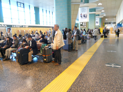 Gruppi di cinesi e giapponesi in attesa in aeroporto a Malpensa